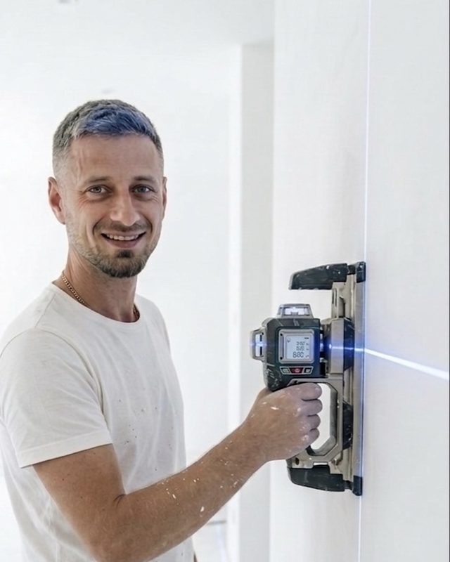 Gheorghe Moscalu bei der Arbeit mit einem Rotationslaser an einer frisch gespachtelten Wand